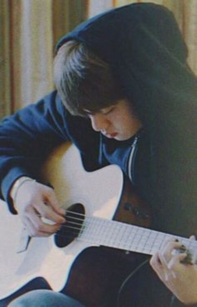 Jin tocando la guitarra en una foto